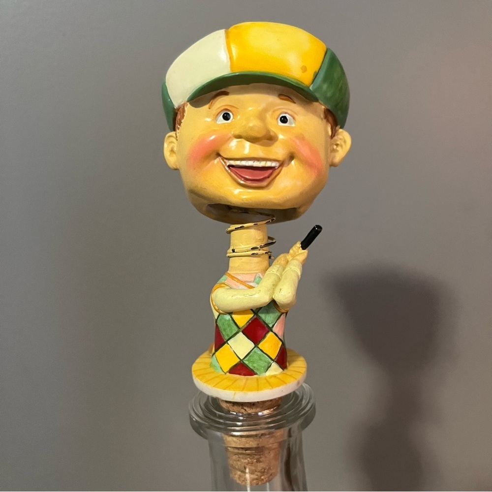 Vintage ceramic golfer bottle stopper with a bobblehead design.